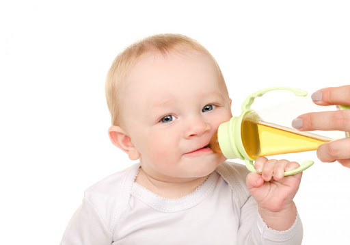 Bebê tomando chá no copinho. Qual chá para a cólica do bebê?